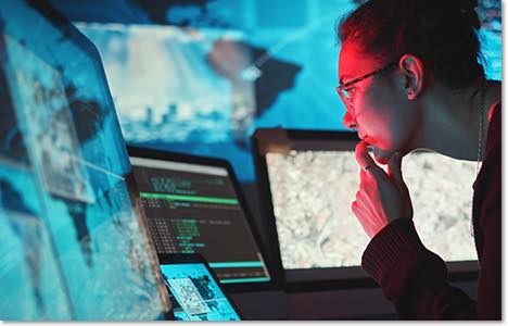 Person with a messy bun and glasses working in a SOC