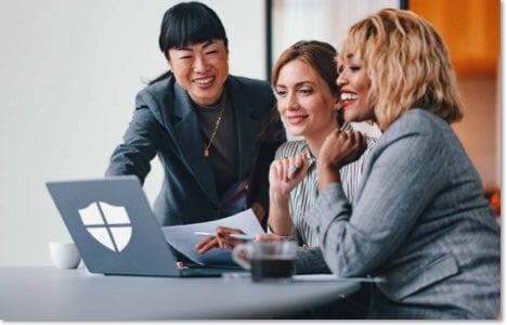 3 businesswomen gathered around a laptop