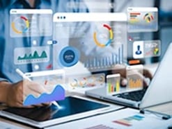 colorful charts and graphs floating in the air above an open laptop and tablet
